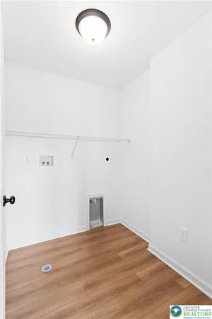 a view of a hallway with a white walls and a painting on the wall