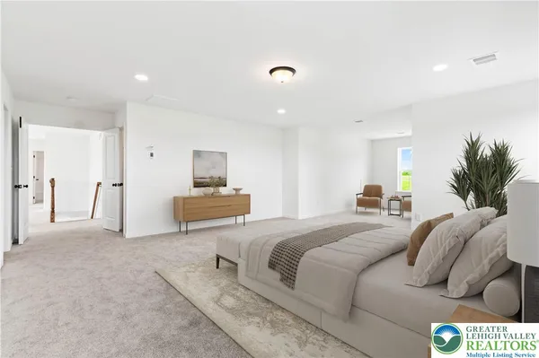 a spacious bedroom with a bed a couch and dresser in it
