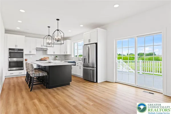 a kitchen with kitchen island stainless steel appliances a sink and a refrigerator