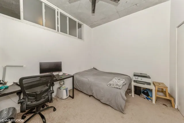 a bedroom with a bed and a desk