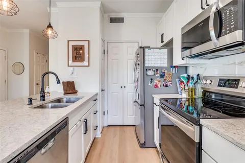 a kitchen with stainless steel appliances granite countertop a refrigerator and a sink
