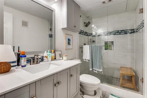 a bathroom with a sink toilet double vanity and shower