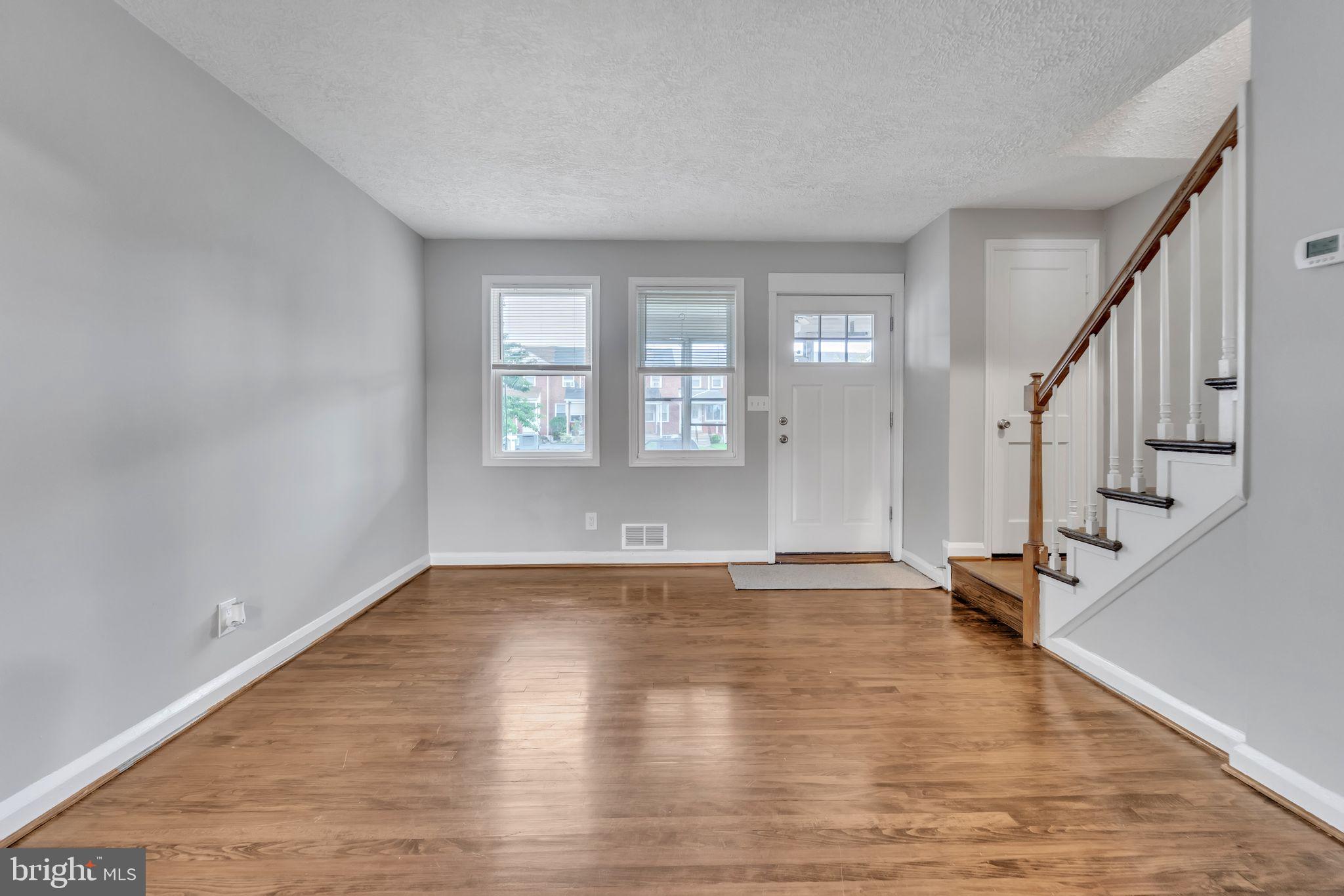 3422 Dunran Road Dundalk, MD 21222 - Photo 5 of 30 a view of an empty room with wooden floor and a window