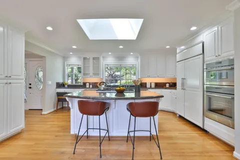 a kitchen with a table chairs and kitchen view