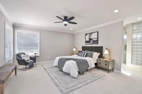 a bedroom with a bed ceiling fan and a fireplace