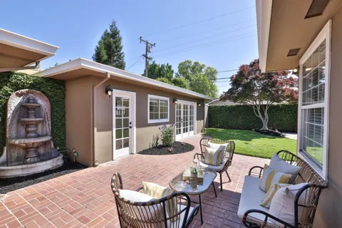 a view of a patio with table and chairs and potted plants