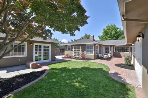 a view of a house with a yard and sitting area