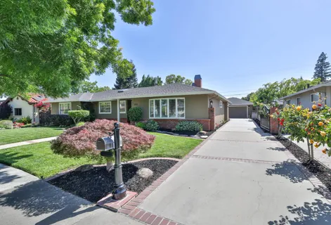a front view of a house with yard and green space