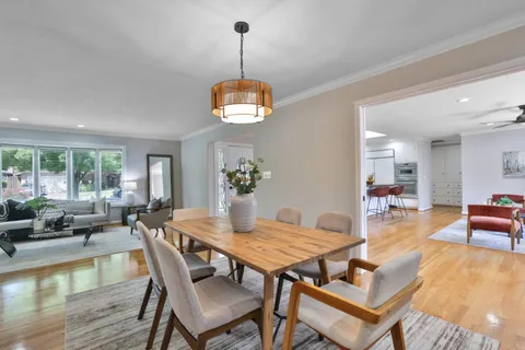 a view of a dining room with furniture wooden floor and a chandelier