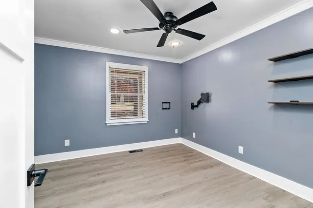 an empty room with wooden floor and windows
