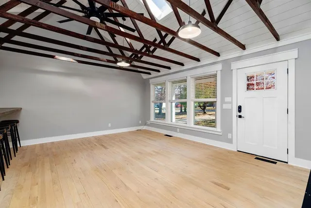 a kitchen with stainless steel appliances kitchen island a table chairs refrigerator and sink