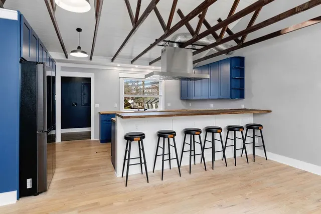 a kitchen with stainless steel appliances granite countertop wooden cabinets a sink and dishwasher with wooden floor