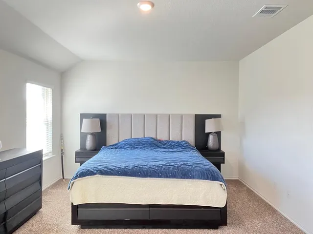 a room with a bed and dresser