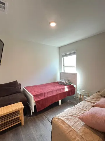 a bedroom with two beds and window