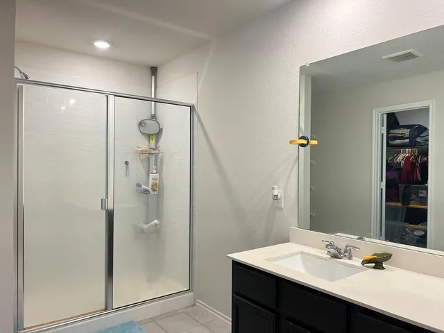 a bathroom with a sink shower and a mirror