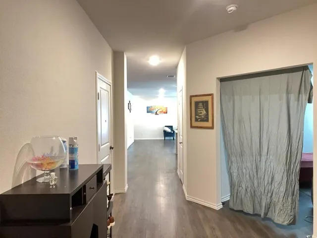 a view of a hallway to a livingroom with furniture