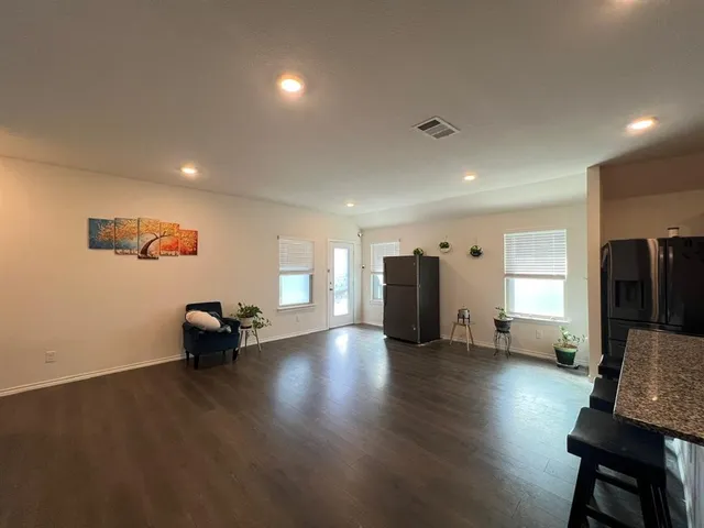 a view of empty room with wooden floor and furniture