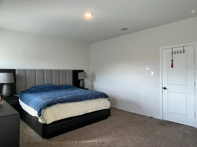 a bedroom with a bed and a night stand