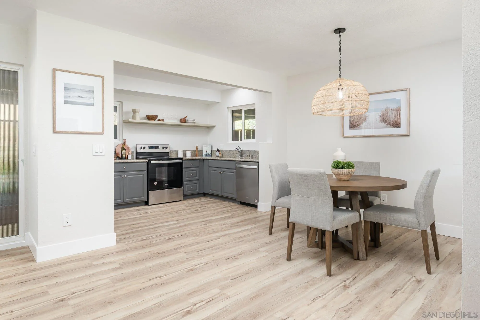2610 Torrey Pines Road, Unit C33 La Jolla, CA 92037 - Photo 3 of 24 a kitchen with kitchen island a dining table chairs stainless steel appliances and cabinets