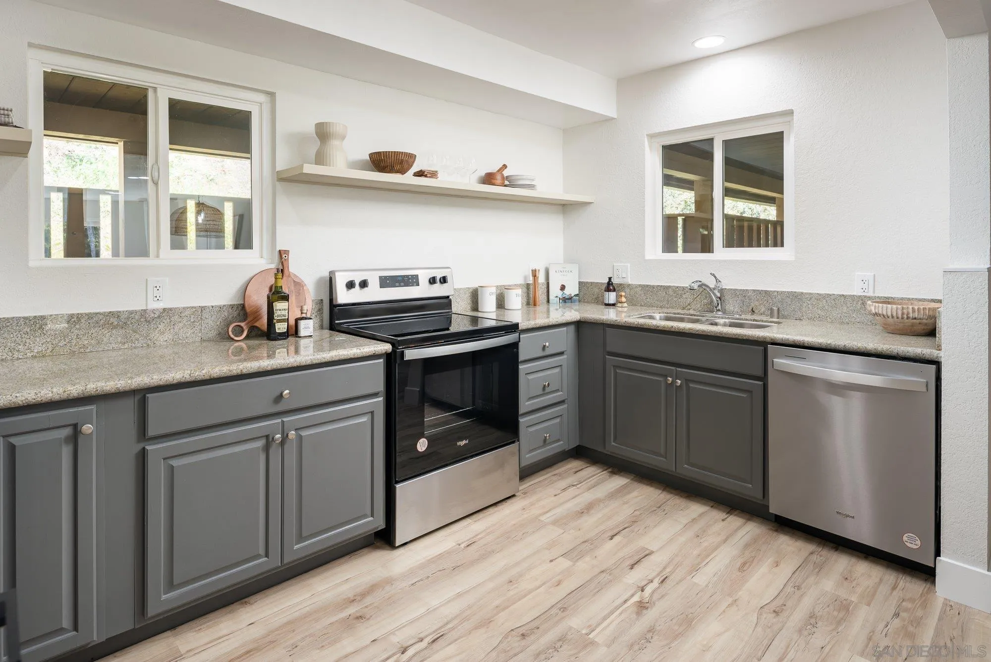2610 Torrey Pines Road, Unit C33 La Jolla, CA 92037 - Photo 8 of 24 a kitchen with stainless steel appliances granite countertop a sink stove and wooden cabinets