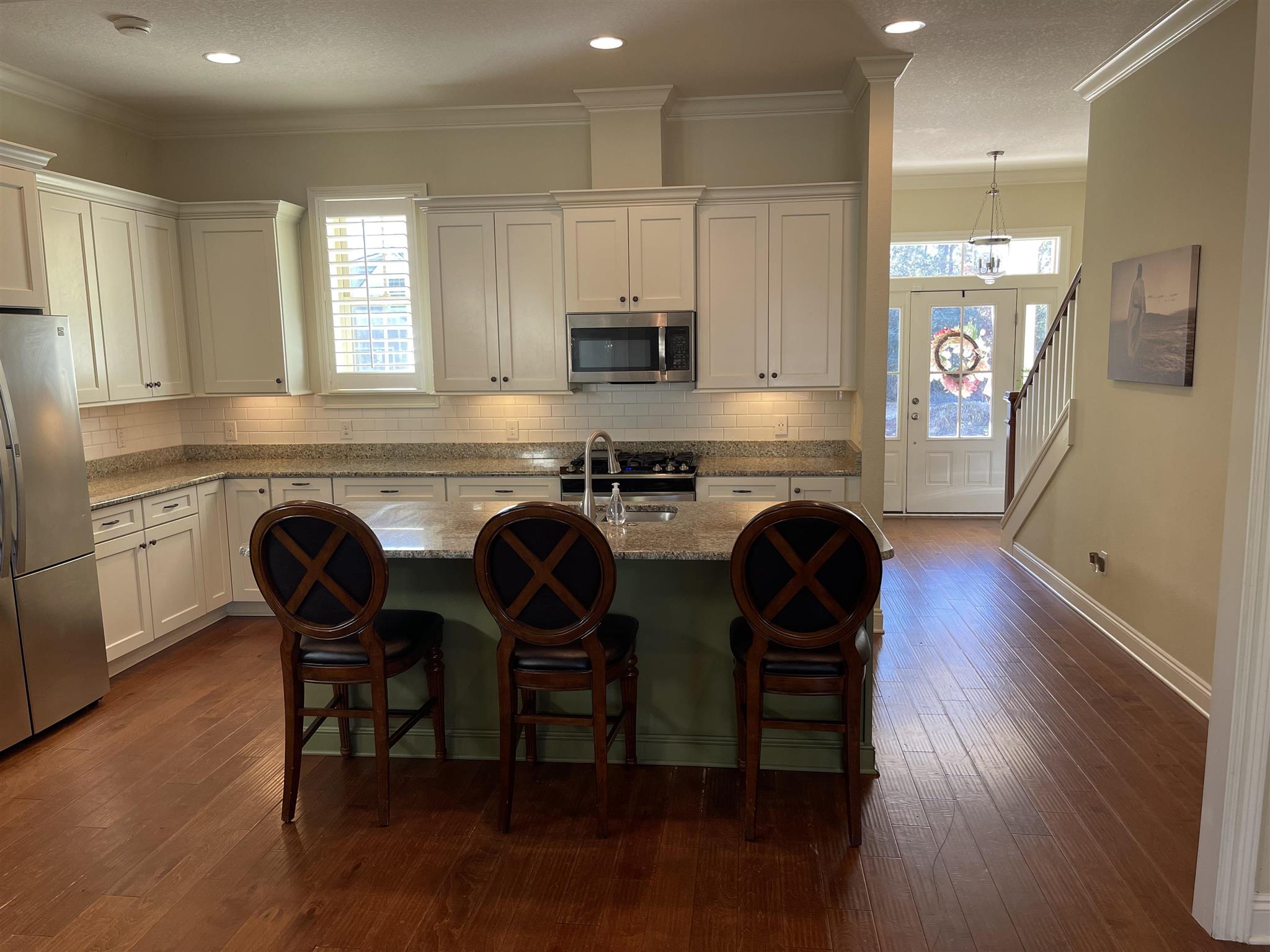 10692 Squall Line Road Pensacola, FL 32507 - Photo 10 of 29 a kitchen with stainless steel appliances granite countertop wooden floors a stove a microwave a sink and a refrigerator