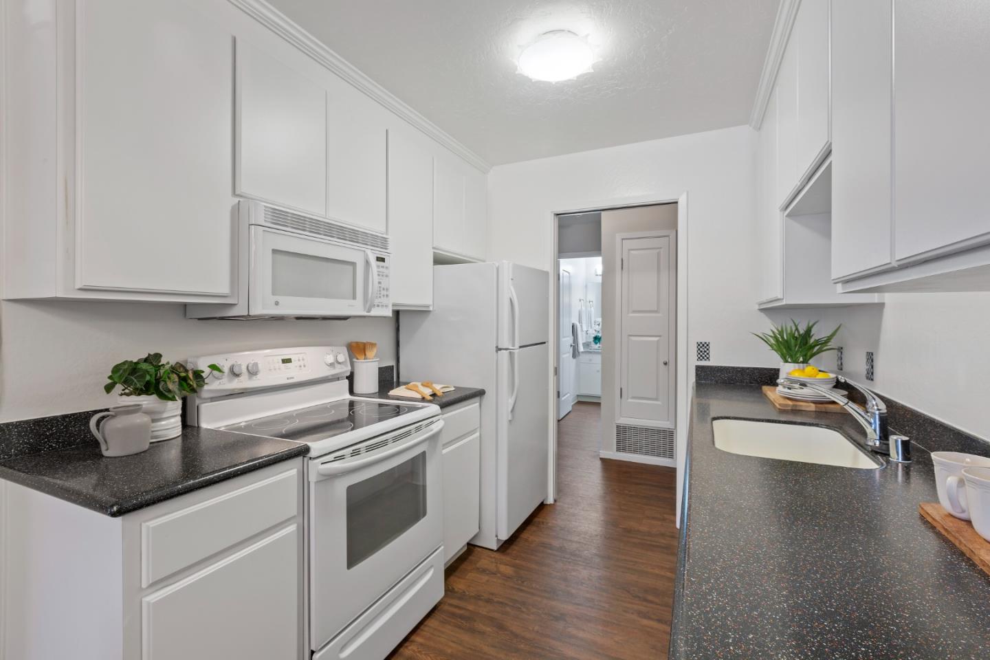 255 South Rengstorff Avenue, Unit 96 Mountain View, CA 94040 - Photo 12 of 20 a kitchen with stainless steel appliances granite countertop a refrigerator a stove and a wooden floors