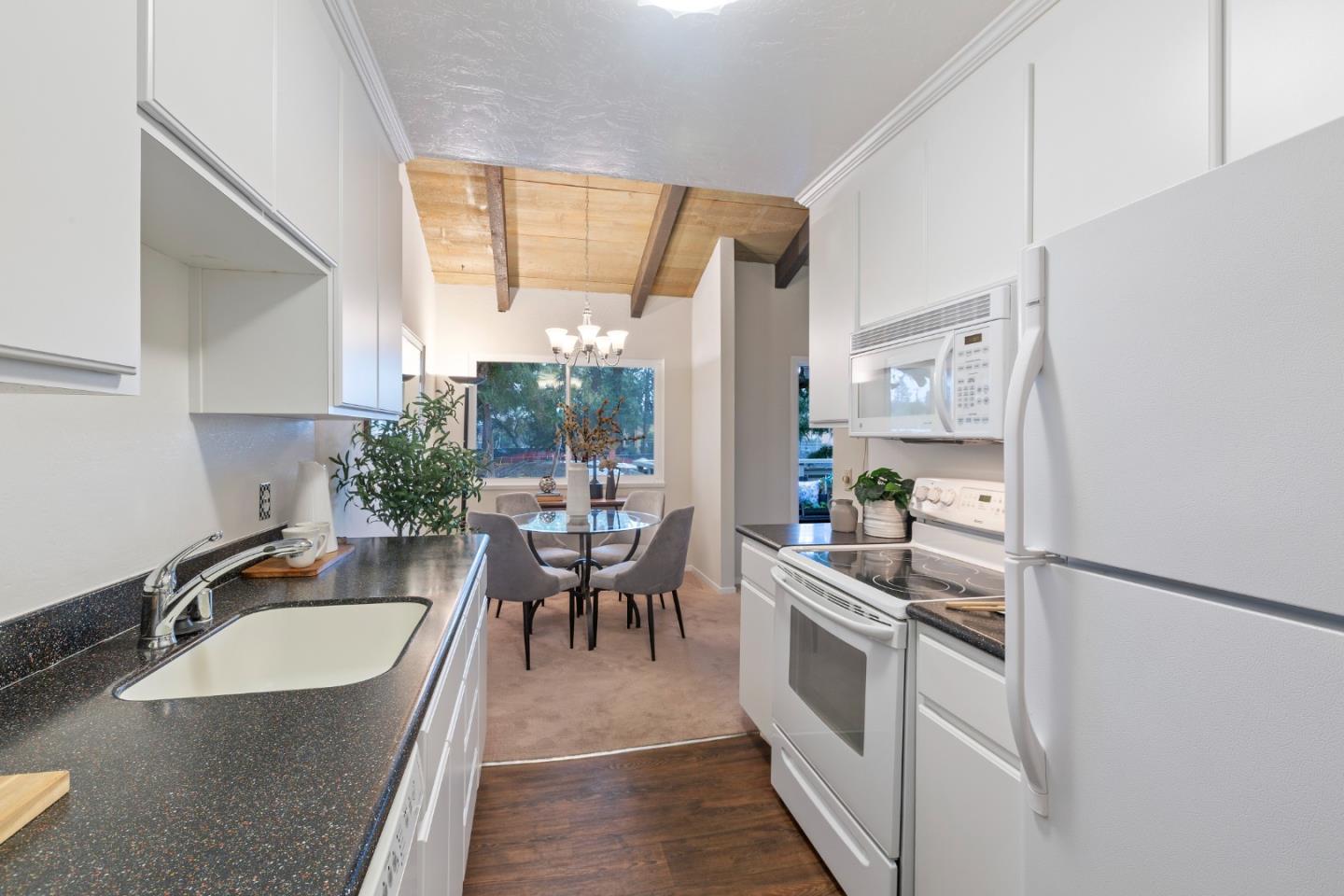 255 South Rengstorff Avenue, Unit 96 Mountain View, CA 94040 - Photo 9 of 20 a kitchen with stainless steel appliances granite countertop a sink a stove and white cabinets next to a window