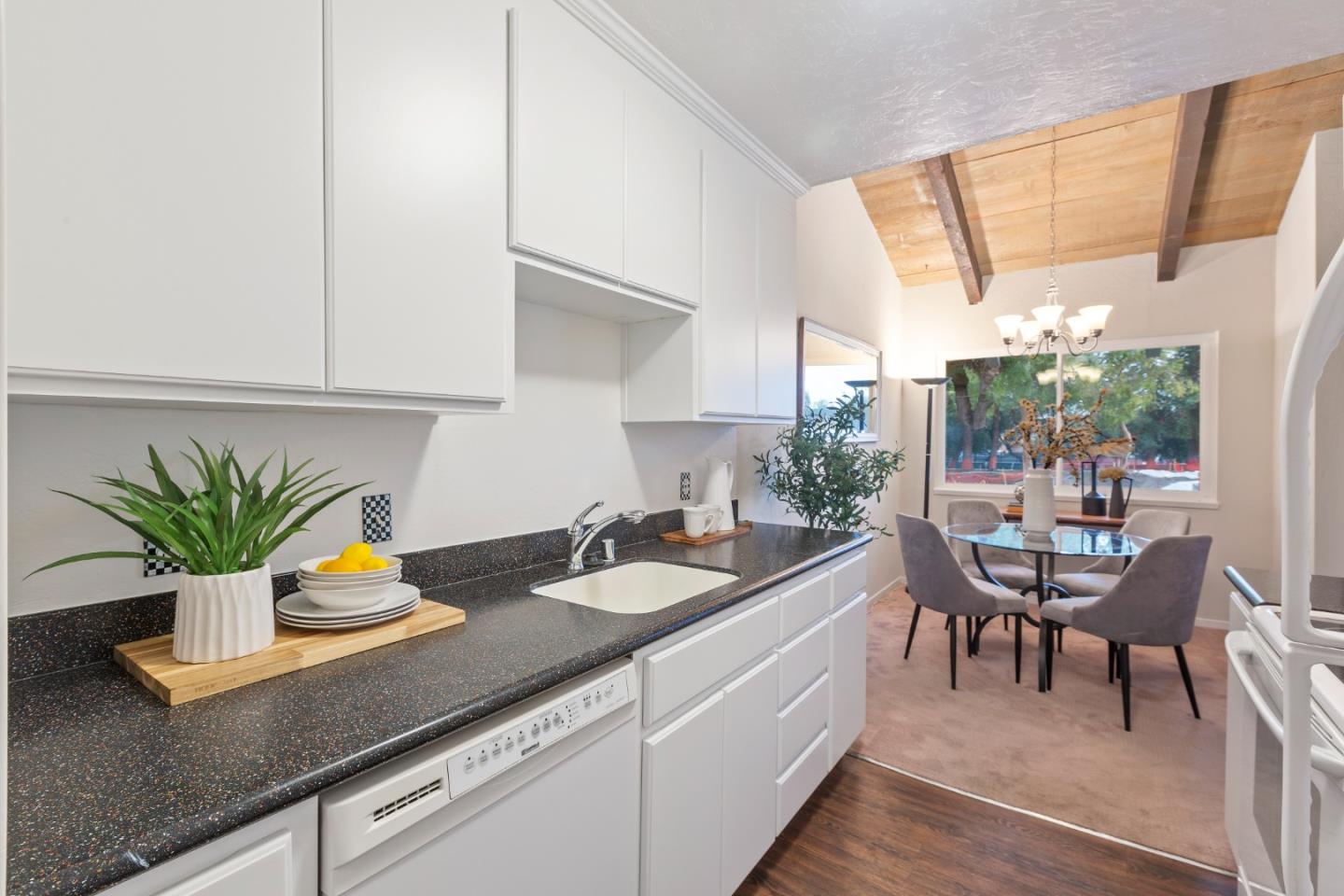 255 South Rengstorff Avenue, Unit 96 Mountain View, CA 94040 - Photo 10 of 20 a kitchen with a sink a table and chairs in it