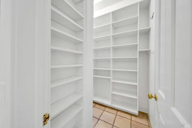 a view of walk in closet with empty racks