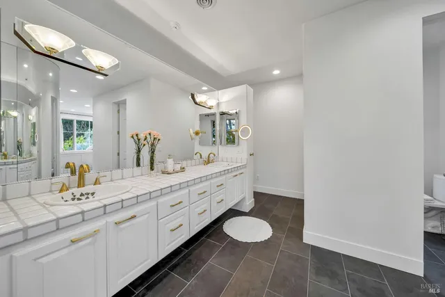 a spacious bathroom with a double vanity sink and a mirror