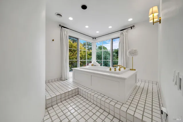 a bathroom with a bathtub sink and mirror