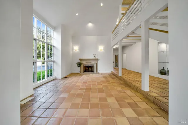 a view of empty room with a fireplace and windows