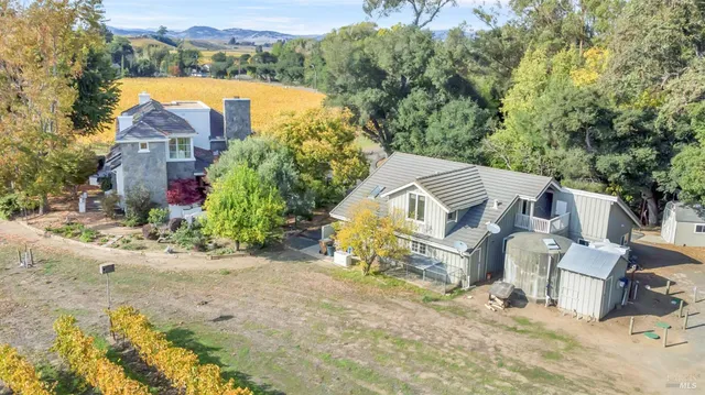 an aerial view of a house with a yard and lake view