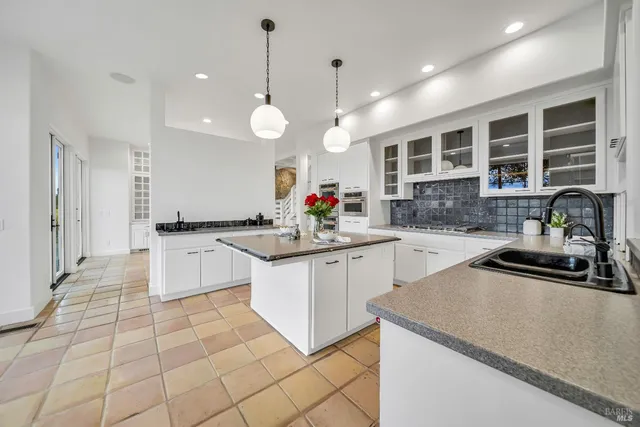 a large kitchen with granite countertop a sink and cabinets