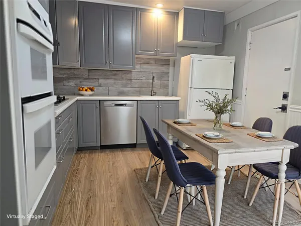 a kitchen with a table chairs refrigerator and cabinets