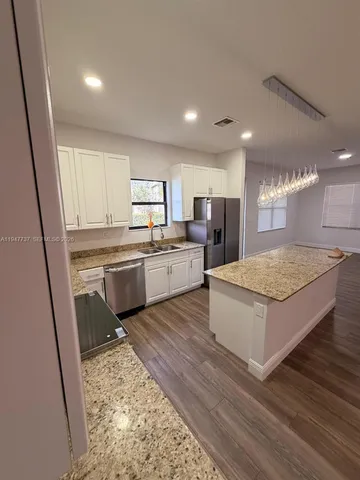 a view of kitchen with sink microwave and refrigerator