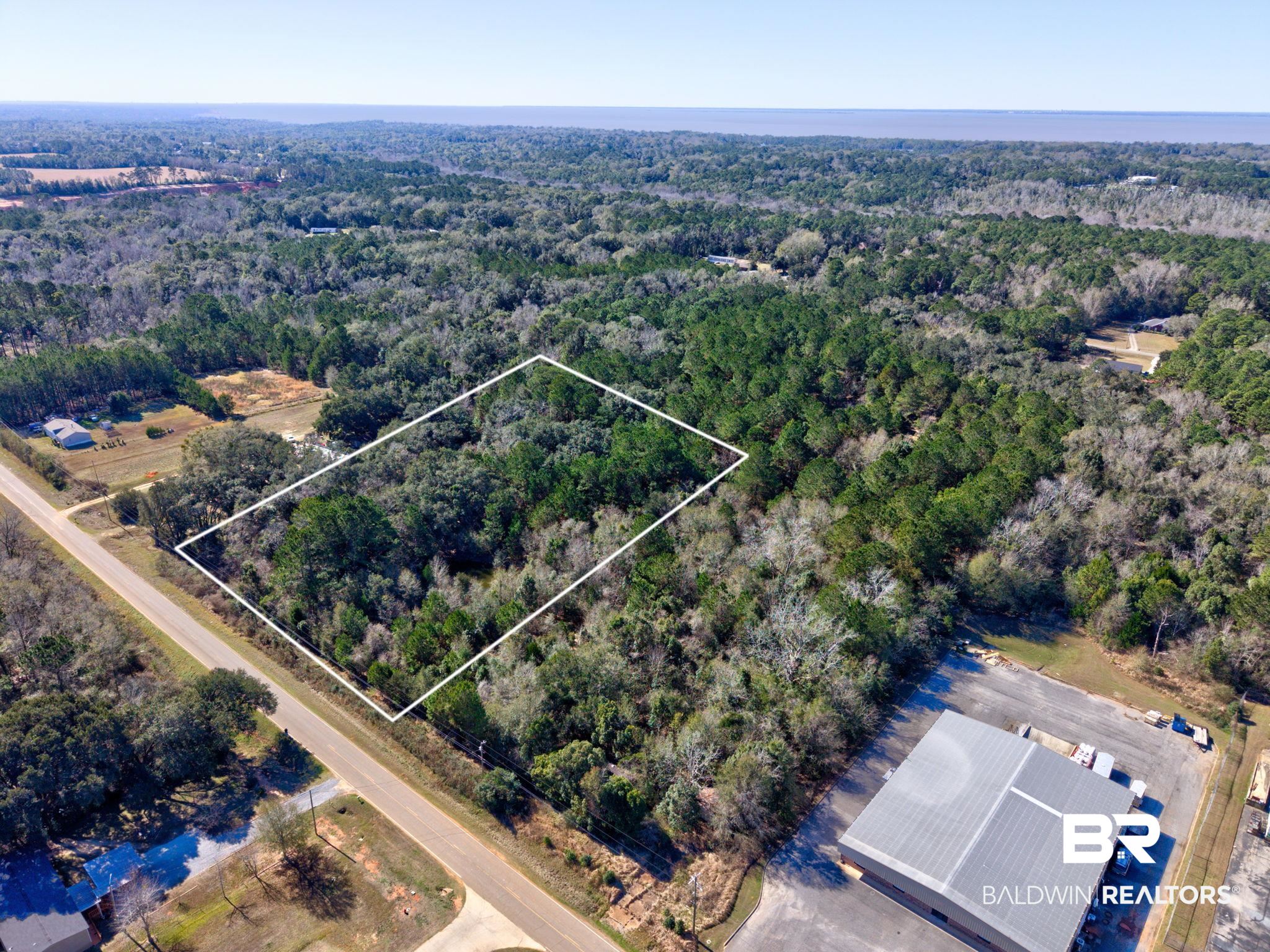 25280 Friendship Road Daphne, AL 36526 - Photo 5 of 34 Aerial view of property's location featuring property boundaries highlighted and a heavily wooded area