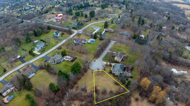 an aerial view of a house with a yard and lake view