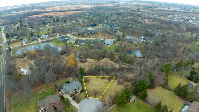 a view of a dry yard with wooden fence