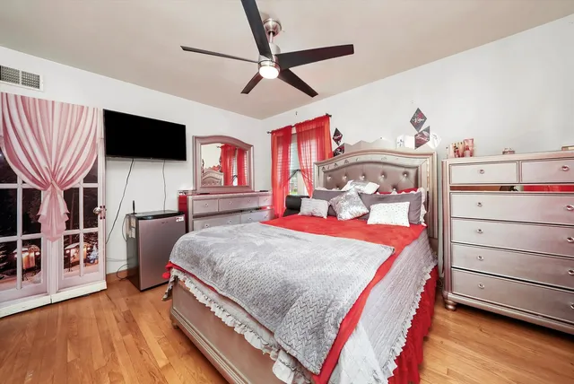 a bedroom with a bed and a flat tv screen on the dresser