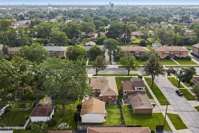an aerial view of residential houses with outdoor space and parking