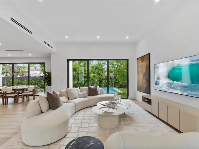 a large kitchen with stainless steel appliances a large counter top a sink a stove and a refrigerator