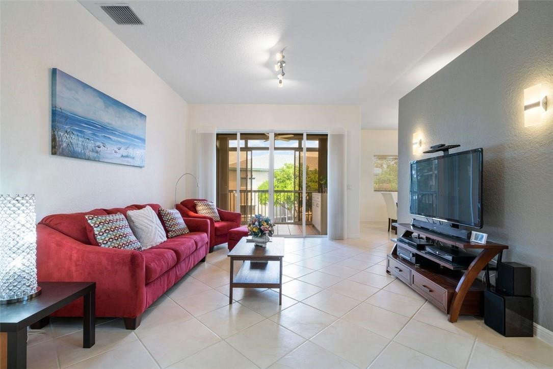 7847 Exeter Boulevard East, Unit 203 Tamarac, FL 33321 - Photo 11 of 36 a living room with furniture and a flat screen tv