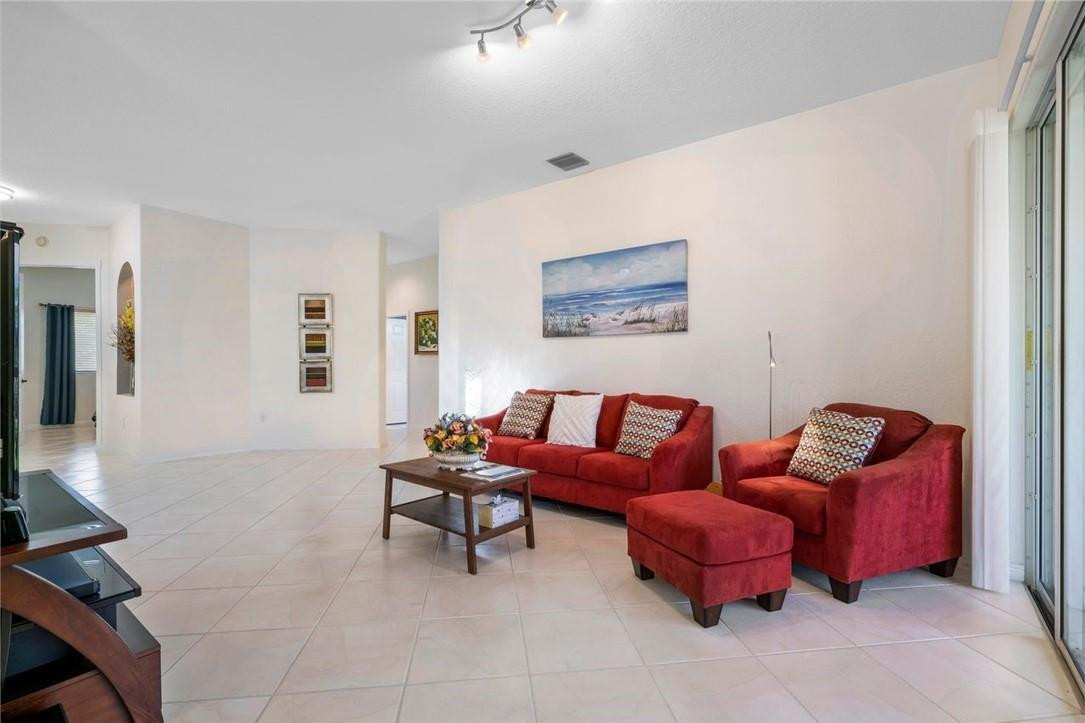 7847 Exeter Boulevard East, Unit 203 Tamarac, FL 33321 - Photo 12 of 36 a living room with furniture a couch and a flat screen tv