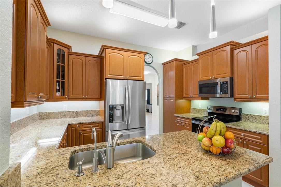 7847 Exeter Boulevard East, Unit 203 Tamarac, FL 33321 - Photo 16 of 36 a kitchen with stainless steel appliances granite countertop a sink stove and refrigerator