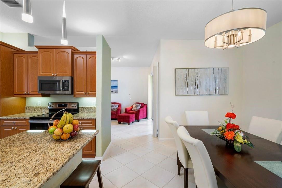 7847 Exeter Boulevard East, Unit 203 Tamarac, FL 33321 - Photo 18 of 36 a bedroom with furniture and a chandelier