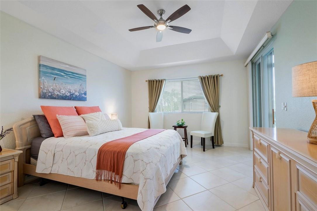 7847 Exeter Boulevard East, Unit 203 Tamarac, FL 33321 - Photo 20 of 36 a bedroom with a bed and a chandelier