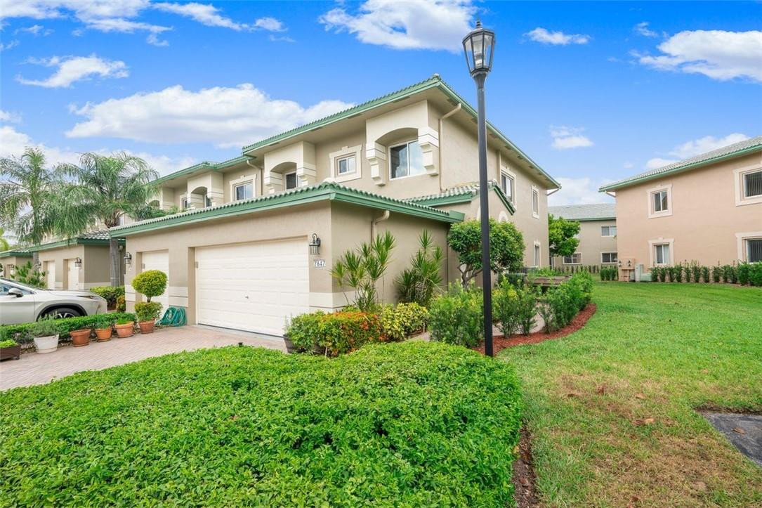 7847 Exeter Boulevard East, Unit 203 Tamarac, FL 33321 - Photo 2 of 36 a view of a house with a yard and plants