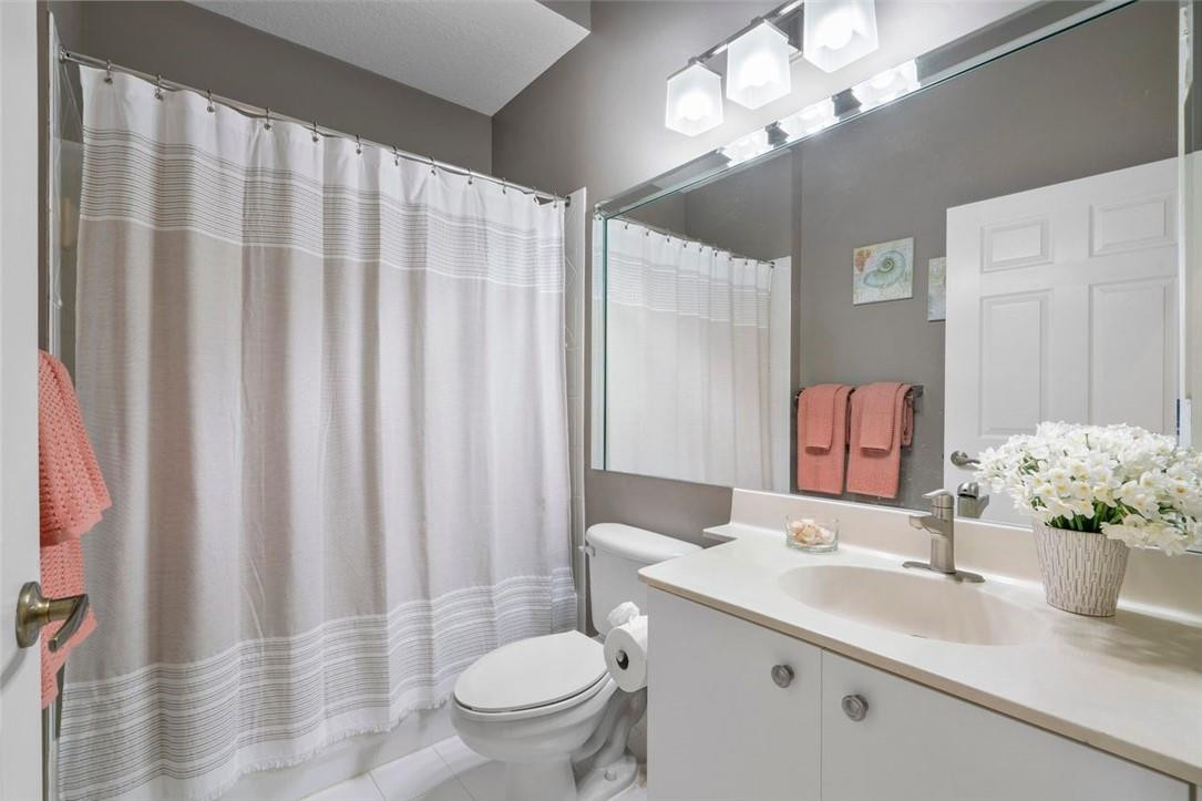 7847 Exeter Boulevard East, Unit 203 Tamarac, FL 33321 - Photo 27 of 36 a bathroom with a sink a toilet and a mirror