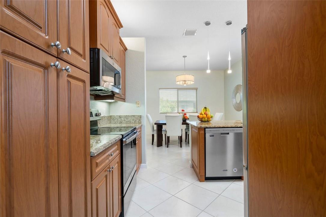 7847 Exeter Boulevard East, Unit 203 Tamarac, FL 33321 - Photo 30 of 36 a open kitchen with stainless steel appliances granite countertop a refrigerator and a stove top oven
